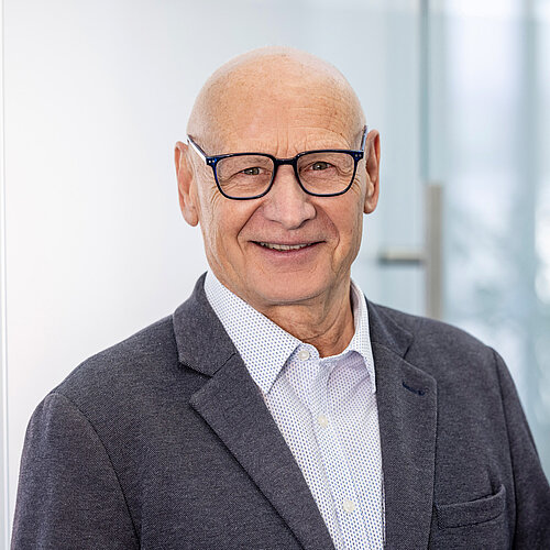 Gerhard Staiger Porträt von Gerhard Staiger mit Brille im Anzug vor Glaswand