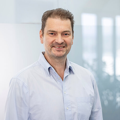 Andreas Wiebe Porträt von Andreas Wiebe in hellblauem Hemd vor Bürohintergrund